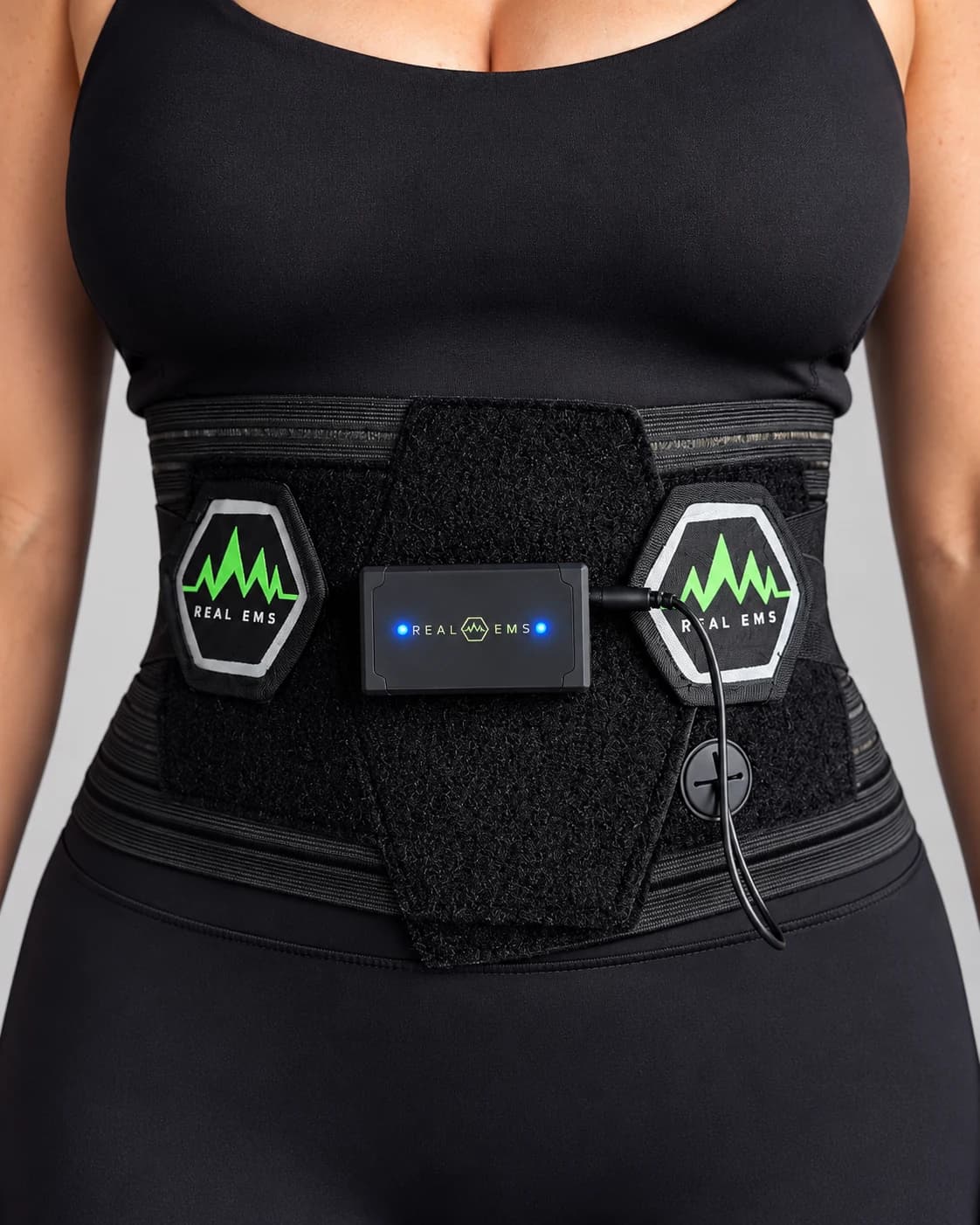 Närbild av REAL EMS Champion Belt med elektrodpads och kontrollenhet